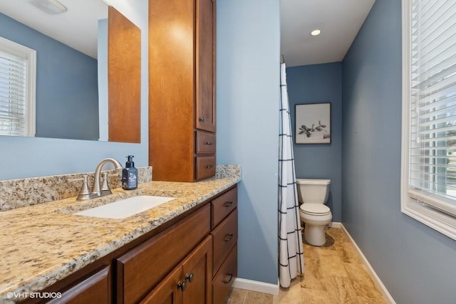 bathroom featuring plenty of natural light, toilet, and vanity