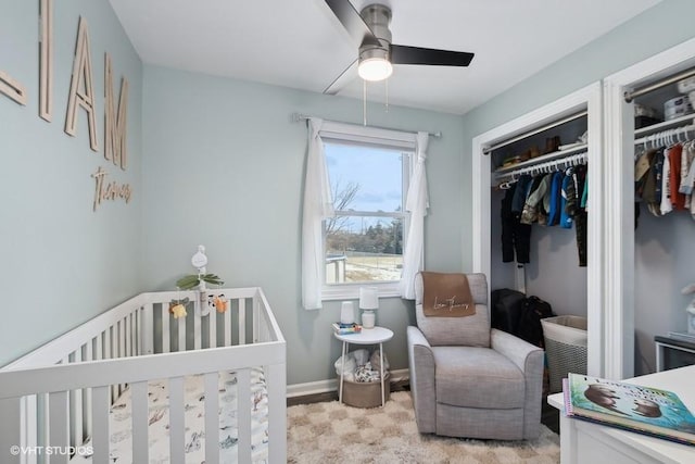 carpeted bedroom featuring ceiling fan, a nursery area, and a closet