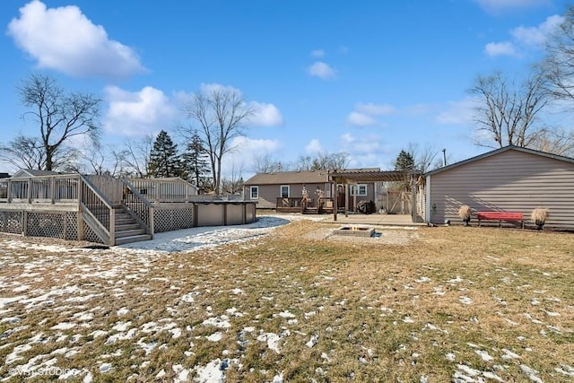 snowy yard with a pool side deck and a pergola