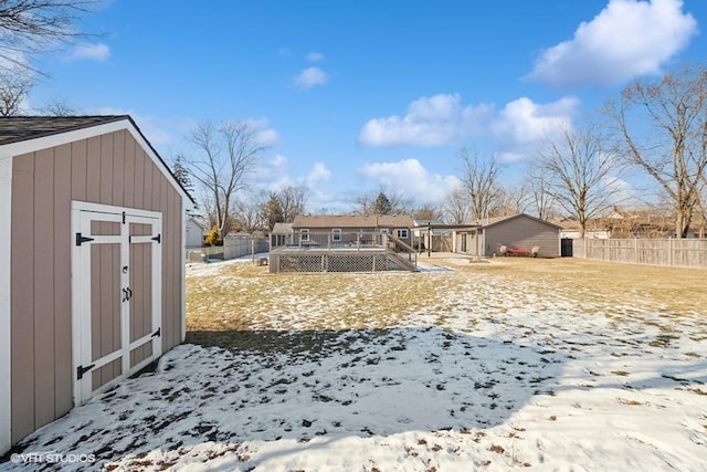 snowy yard featuring a storage shed