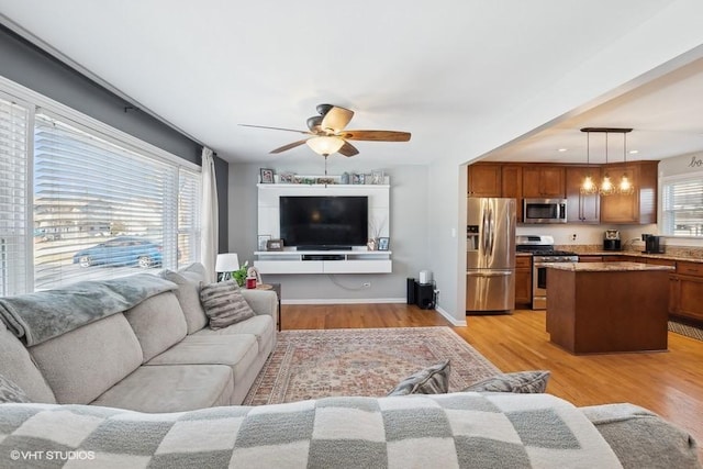 living room with ceiling fan, a healthy amount of sunlight, and light hardwood / wood-style floors