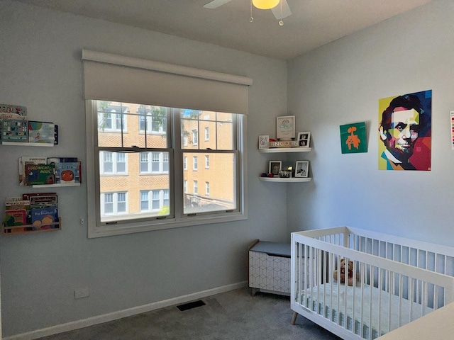 carpeted bedroom featuring a crib and baseboards