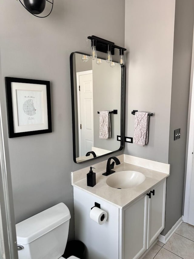 half bath featuring vanity, toilet, and tile patterned floors