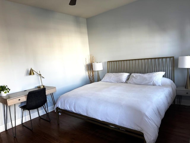 bedroom featuring ceiling fan, baseboards, and dark wood-style flooring