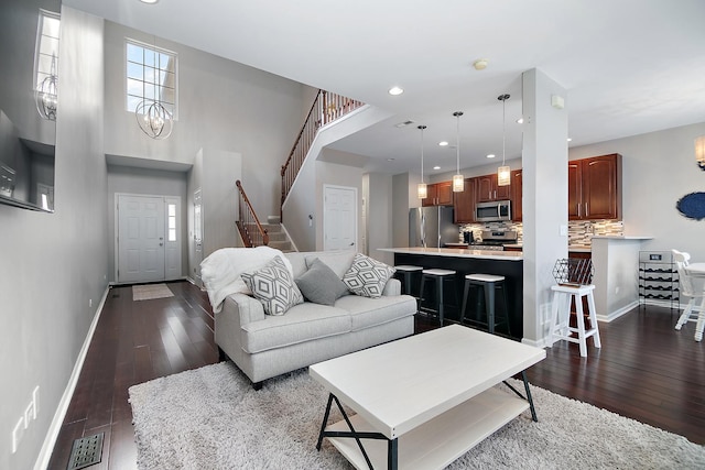 living room with dark hardwood / wood-style flooring and an inviting chandelier