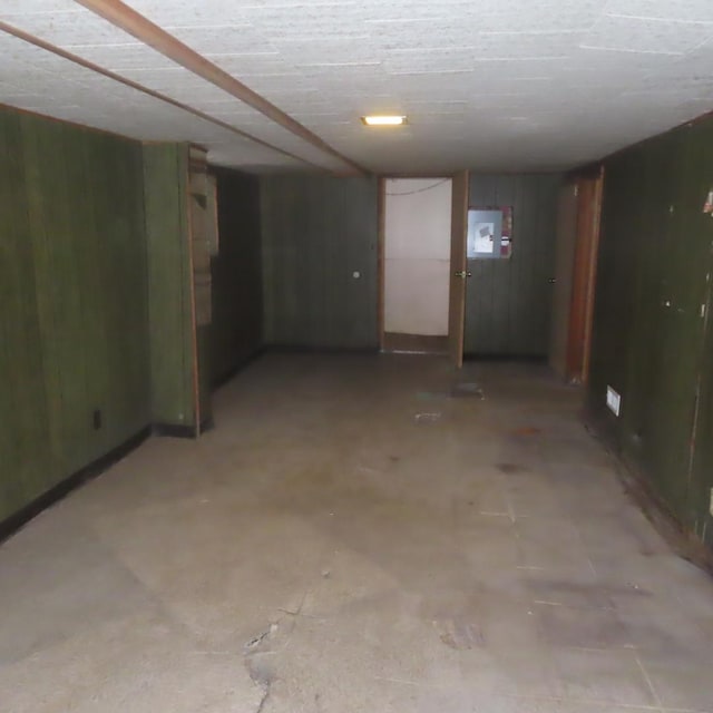 basement with wooden walls and electric panel