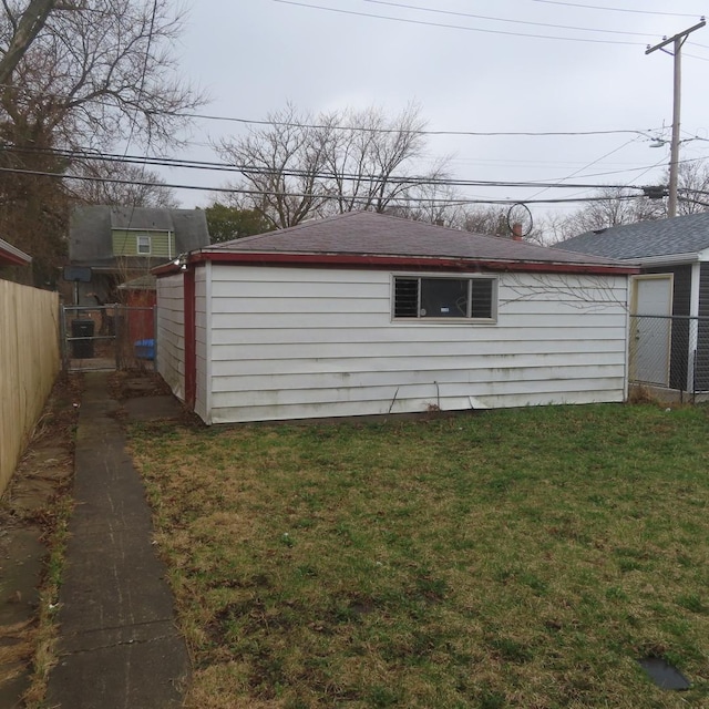 view of property exterior featuring a lawn, fence, and roof with shingles
