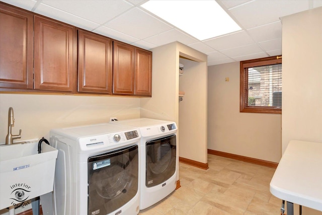 clothes washing area featuring cabinets, washer and dryer, and sink