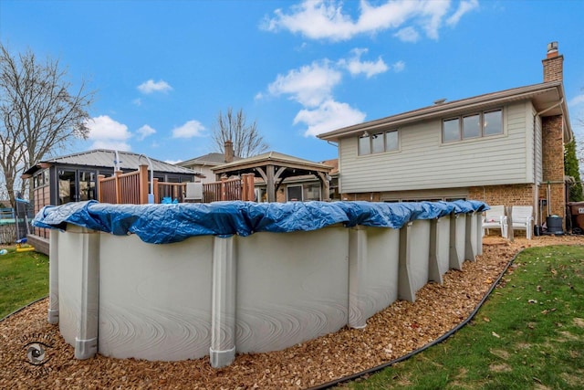 back of property with a gazebo and a covered pool