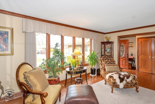 living area with ornamental molding and hardwood / wood-style floors