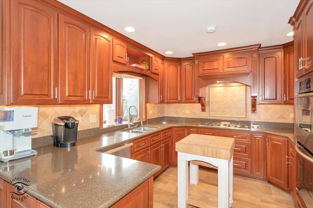 kitchen featuring decorative backsplash, sink, stainless steel appliances, custom range hood, and dark stone counters