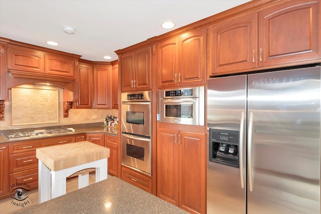 kitchen with stainless steel appliances and tasteful backsplash