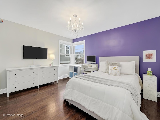 bedroom with dark hardwood / wood-style floors and a notable chandelier