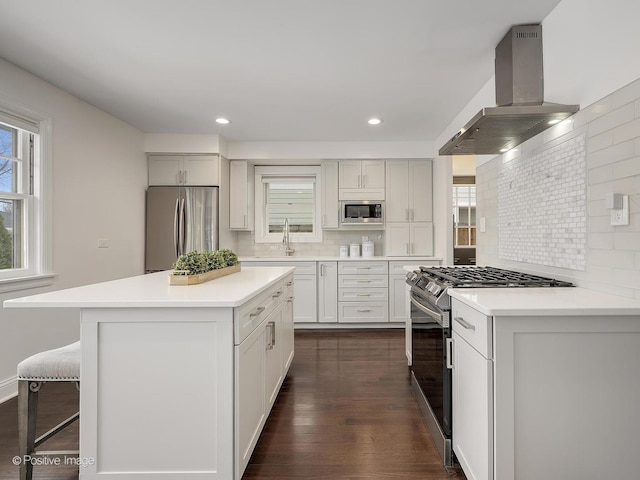 kitchen with range hood, a kitchen breakfast bar, dark wood-type flooring, backsplash, and stainless steel appliances