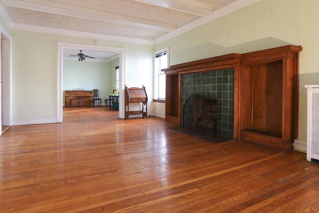 unfurnished living room featuring ceiling fan, beam ceiling, a fireplace, and wood-type flooring