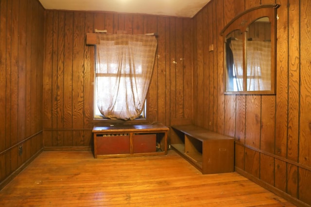 mudroom featuring light wood-type flooring and wood walls