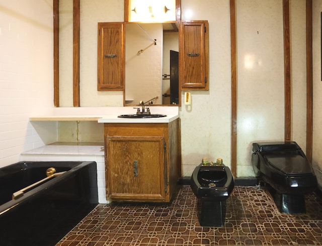 bathroom featuring toilet, a bath, and vanity