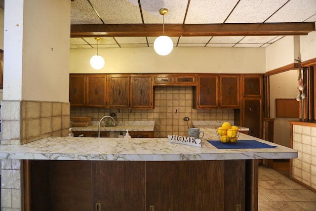 kitchen with sink, pendant lighting, decorative backsplash, and tile patterned floors