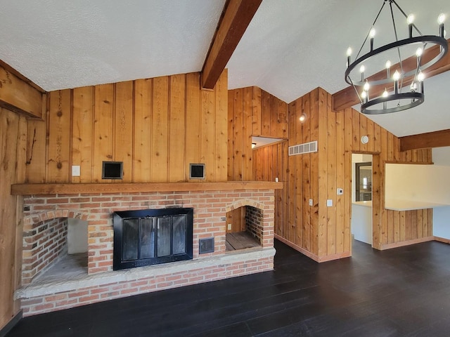 unfurnished living room with lofted ceiling with beams, a brick fireplace, dark hardwood / wood-style flooring, and a textured ceiling