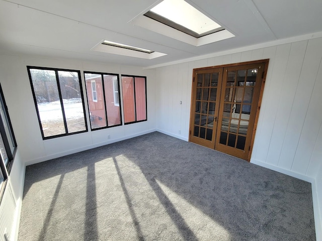 carpeted spare room with a skylight and french doors