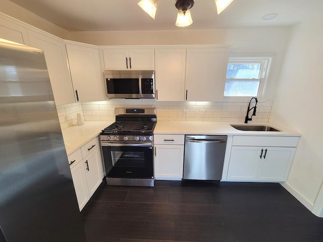 kitchen with tasteful backsplash, dark hardwood / wood-style floors, sink, stainless steel appliances, and white cabinets