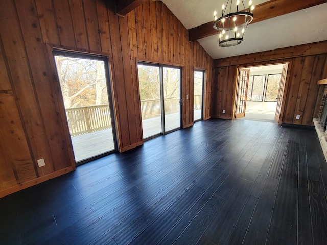 interior space featuring dark hardwood / wood-style flooring, lofted ceiling with beams, and a notable chandelier