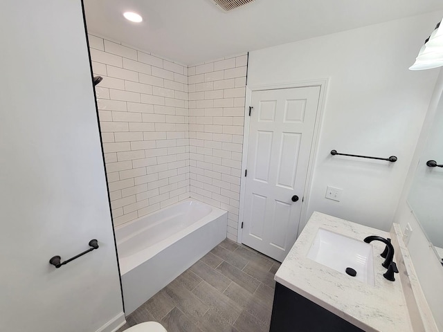 bathroom with tiled shower / bath combo and vanity