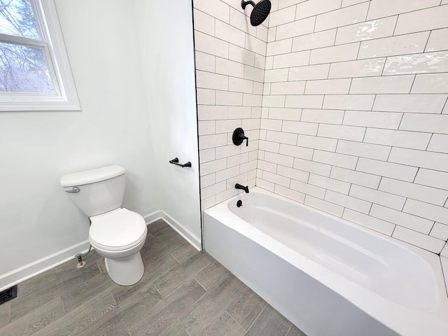 bathroom with toilet and tiled shower / bath combo