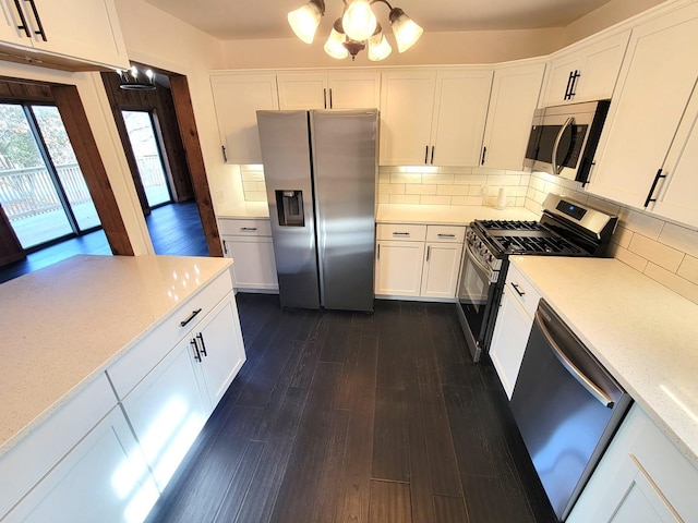 kitchen with white cabinets, dark hardwood / wood-style flooring, stainless steel appliances, decorative backsplash, and a notable chandelier