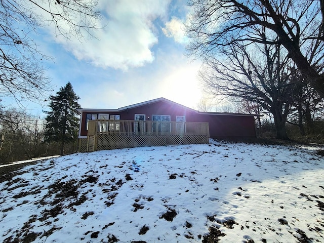 snow covered property with a wooden deck