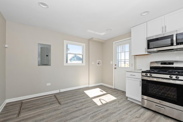 kitchen featuring white cabinetry, a healthy amount of sunlight, stainless steel appliances, and electric panel