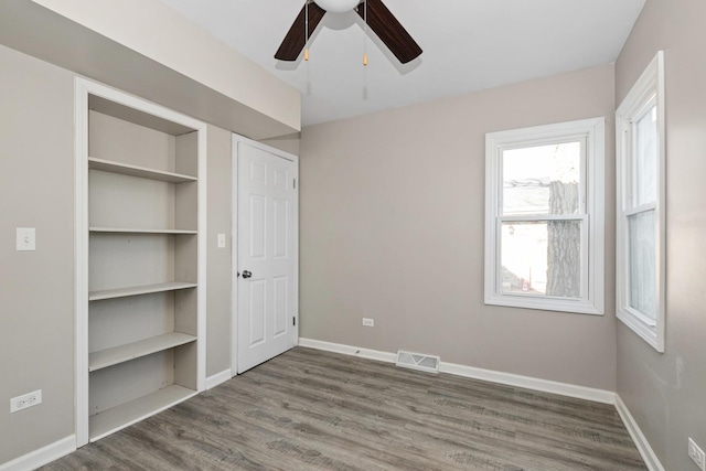 unfurnished bedroom with ceiling fan and hardwood / wood-style floors