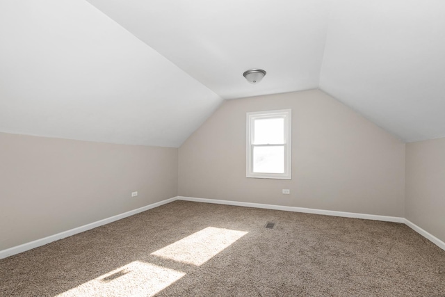 additional living space featuring carpet and vaulted ceiling