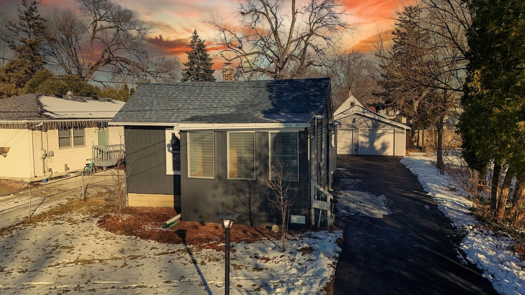 view of snow covered exterior with a garage and an outdoor structure