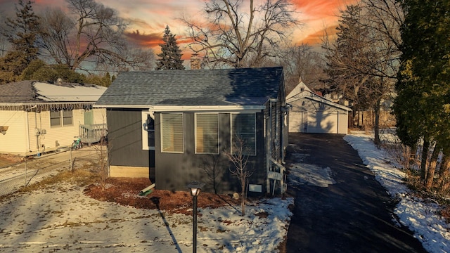 view of snow covered exterior with a garage and an outdoor structure