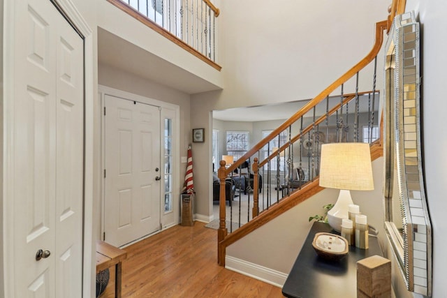 foyer with a towering ceiling and light wood-type flooring