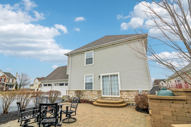 back of house with a garage, area for grilling, and a patio area