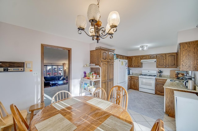 tiled dining room with an inviting chandelier