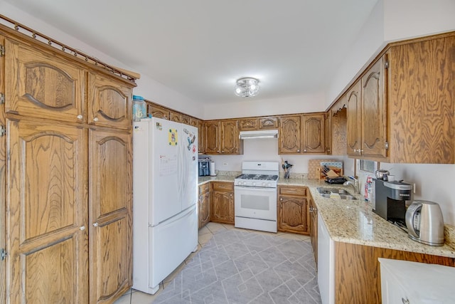 kitchen featuring sink, white appliances, and light stone countertops