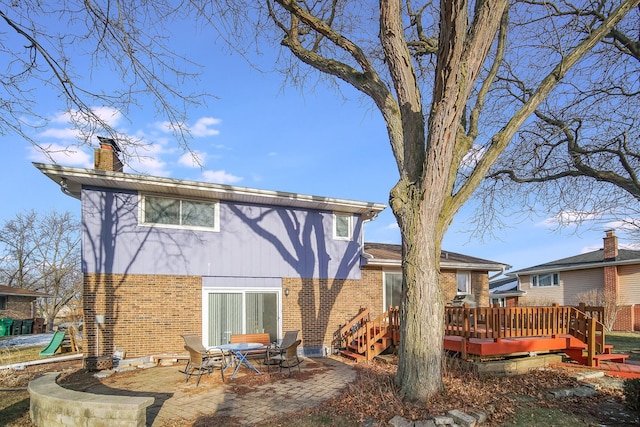 rear view of property featuring a patio area and a wooden deck