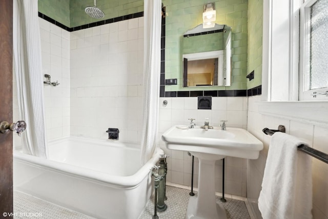 full bathroom with a sink, tile walls, backsplash, tile patterned floors, and shower / tub combo with curtain