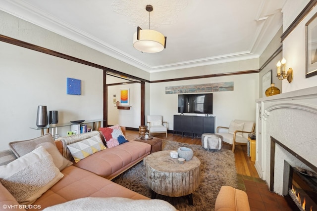 living room featuring a tiled fireplace, wood finished floors, and crown molding