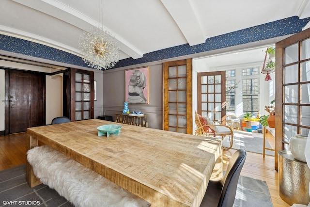 dining room with french doors, beamed ceiling, wood finished floors, and a notable chandelier