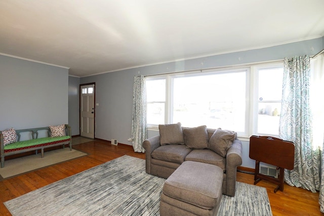 living room featuring hardwood / wood-style floors, crown molding, and a wealth of natural light