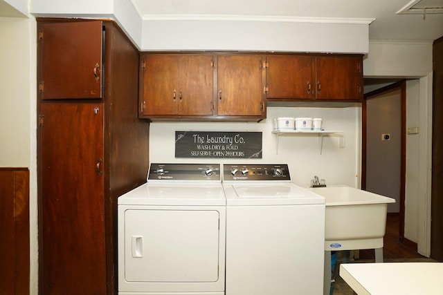 laundry area featuring cabinets, washer and dryer, ornamental molding, and sink