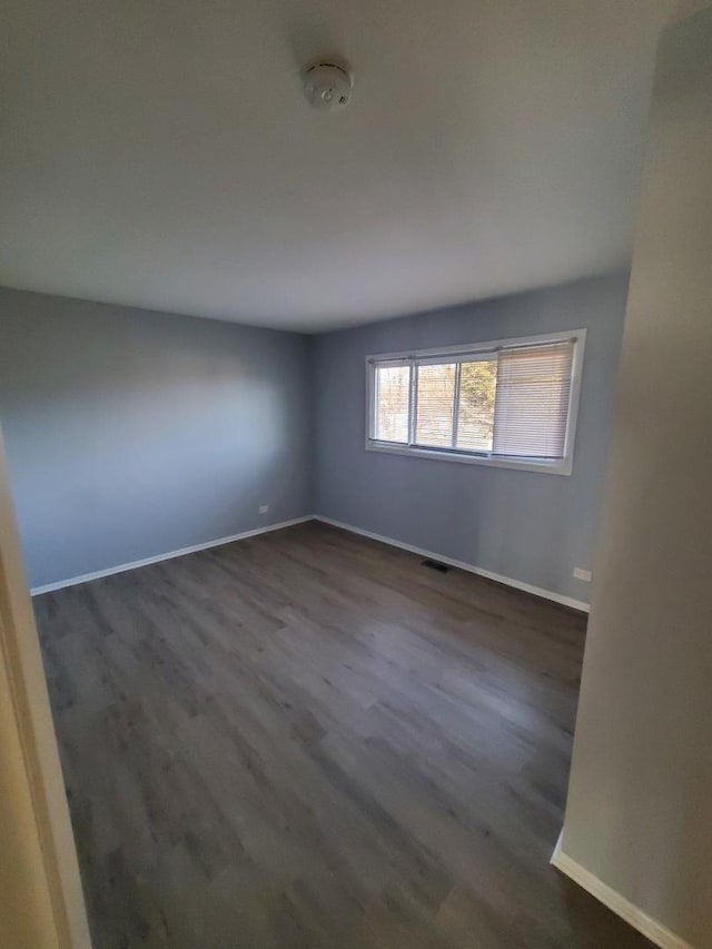 spare room with dark wood-type flooring