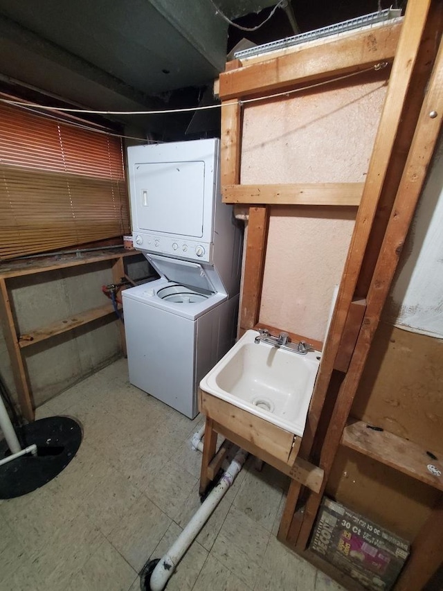 laundry area featuring sink and stacked washer / dryer