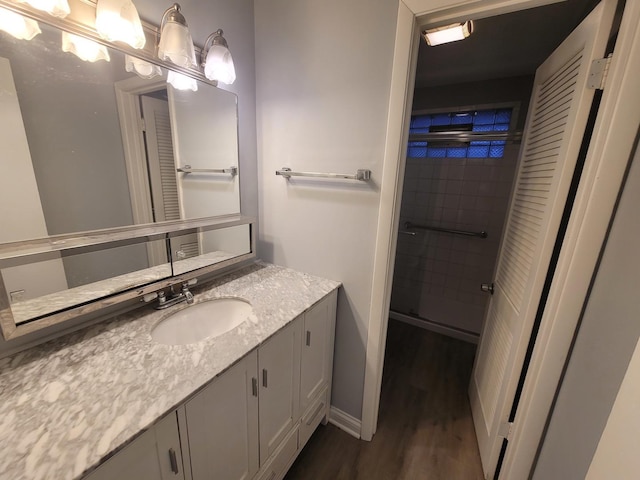 bathroom featuring an enclosed shower, vanity, and hardwood / wood-style floors