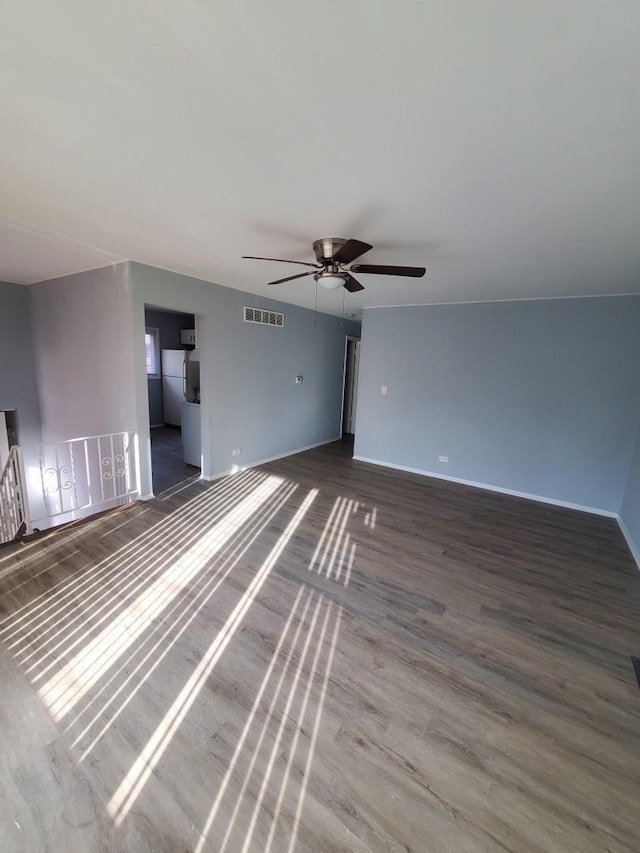 unfurnished living room featuring ceiling fan and dark hardwood / wood-style floors