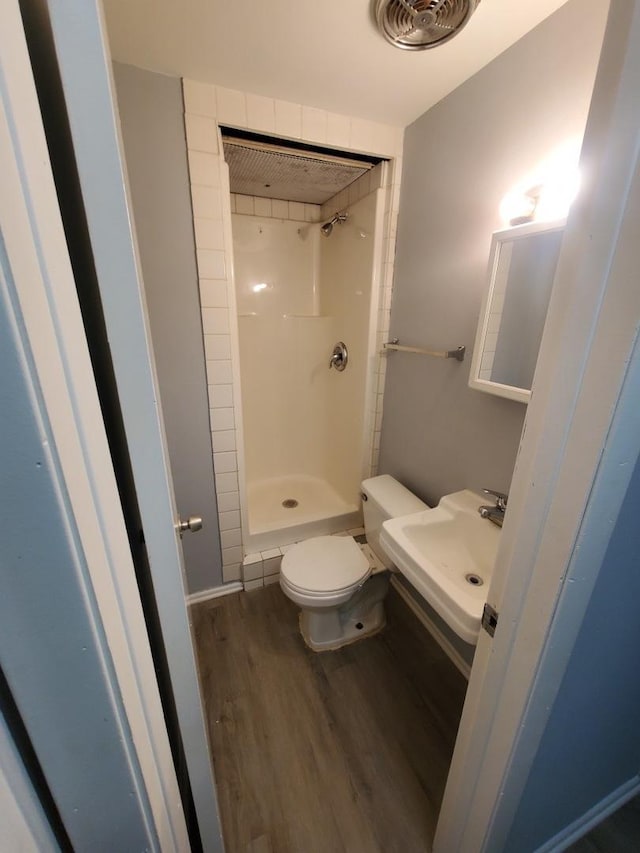 bathroom featuring toilet, a shower, wood-type flooring, and sink